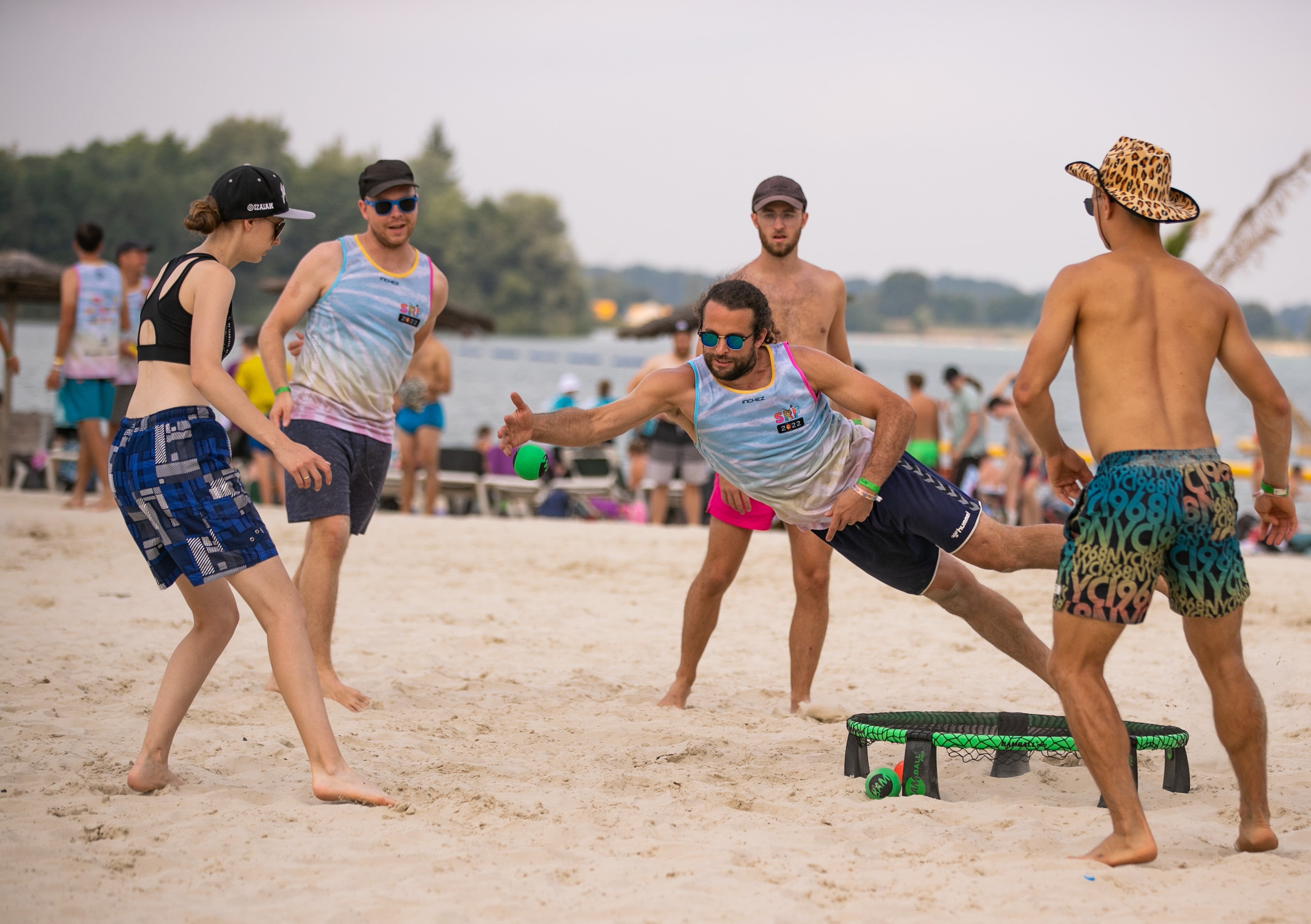 Roundnet Spieler, die den Sport im Sand spielen, ein Spieler ist in der Luft und kurz davor, den Ball aufs Netz zu spielen